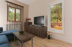 Una sala de estar con un sofá azul y un televisor. en Keko, en Supetar