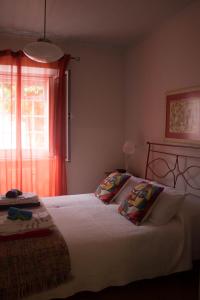 a bedroom with a bed with two pillows and a window at Casa da Igreja Velha in Furnas