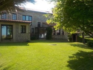 a house with a grass yard in front of it at Posada Tresvalle in Ubiarco