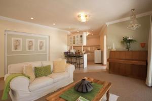 Una sala de estar con un sofá blanco y una mesa. en Somerset West Vacation Rental - Experience the Best of Cape Town - Wine, Golf, Sea, en Somerset West