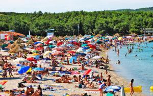 a large crowd of people on a beach at Apartments Loncar-near Zrće beach in Novalja