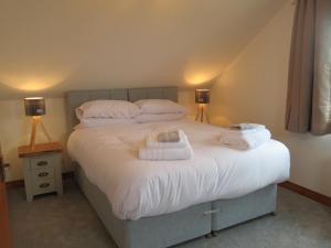1 dormitorio con 1 cama con toallas en Orasaidh Apartment en Stornoway