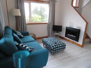 a living room with a blue couch and a fireplace at Orasaidh Apartment in Stornoway