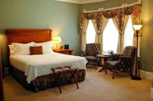 1 dormitorio con 1 cama, 2 sillas y ventana en Cliff House at Pikes Peak, en Manitou Springs