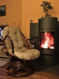 a rocking chair in front of a fireplace at Apartmán Crocus 313 in Štrbské Pleso