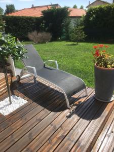 eine Bank, die auf einem Deck im Hof sitzt in der Unterkunft Chambre d'hôtes l'Amaryllis in Cournon-dʼAuvergne