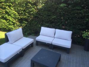 - 2 chaises blanches et une table sur la terrasse dans l'établissement Chambre d'hôtes l'Amaryllis, à Cournon-dʼAuvergne
