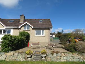 una casa con un banco y una pared de piedra en Orasaidh Apartment, en Stornoway