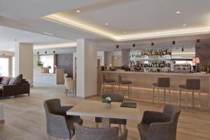 a lobby with a bar and a table and chairs at Design & Suite Hotel Ciarnadoi in Vigo di Fassa