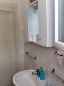 baño con lavabo y armario blanco en Adriatic Apartments, en Dubrovnik