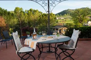 una mesa con copas y una botella de vino en el patio en Albergo Villa Cristina, en Spoleto