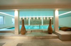 a room with a swimming pool with three vases at Landhaus Sylter Hahn in Westerland