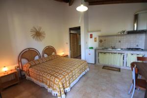 una camera con letto e una cucina con lavandino di Residence Il Giunco a Presicce