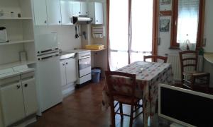 une cuisine avec une table et des chaises et une cuisine avec des placards blancs dans l'établissement Cala Cicala, à Levanto