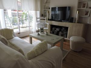 a living room with a couch and a table and a tv at A & E Buenos Aires in Buenos Aires