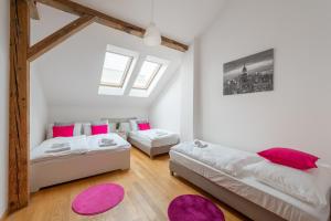 um quarto com 2 camas e almofadas cor-de-rosa em Tesnov Residence Grande Apartments em Praga