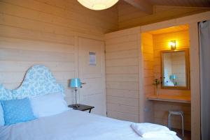 a bedroom with a white bed and a mirror at Lapwing, Skylark & Curlew Seaside Chalets in Kirkbean