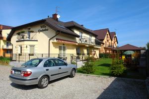 Srebrny samochód zaparkowany przed domem w obiekcie Villa Orchidea w Grzybowie
