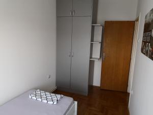 a small white room with a refrigerator and a table at Plaža in Sremska Mitrovica