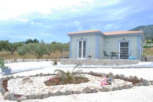 una casa en la playa con un jardín delante en Fiora Villas, en Trapezaki