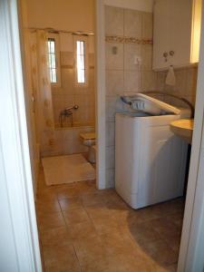 a bathroom with a toilet and a sink and a tub at Deskas House. Two Floor Apartment With Excellent View in Parga