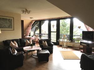 a living room with leather furniture and a large window at Ferienwohnung Will in Walkenried