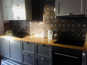 a kitchen with white cabinets and a wooden counter top at House in Kamares - Sifnos in Kamares