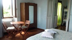 Casale Corte CerroにあるB&B Al Mutpronのベッドルーム1室(ベッド1台、テーブル、椅子付)