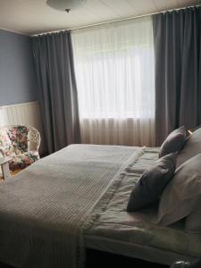 1 dormitorio con cama con almohadas y ventana en Lomatila Ollila Farm Stay, en Kerimäki