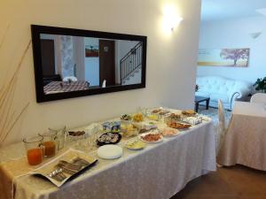 a table with food on it with a mirror at Miramurgia B&B in Gravina in Puglia