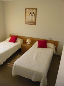 two beds in a hotel room with red pillows at La Loma in Águilas +21 photos