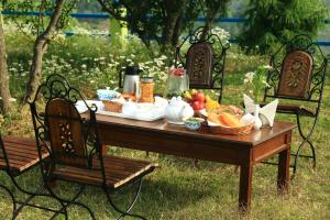 a picnic table with bread and fruit on it at Chirping Orchard, Mukteshwar in Mukteshwar