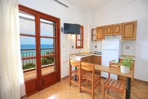 a kitchen with a table and a view of the ocean at Maison La Mer in Agia Paraskevi +70 photos