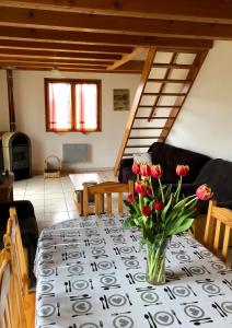une table avec un vase de fleurs au-dessus dans l'établissement Gite De La Mortagne, à Mortagne