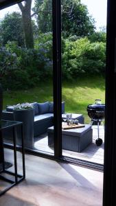 a patio with a couch and a table and a grill at Die Hütten Appartements in Poseritz
