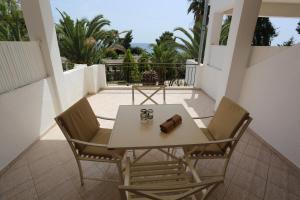 a table and chairs on a balcony with a view at Maison La Mer in Agia Paraskevi