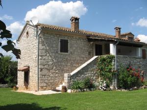 a stone house with a garden and flowers in front of it at Villa Elda in Motovun