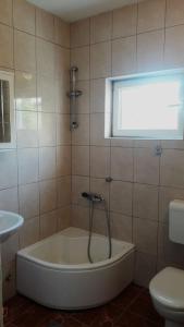 a bath tub in a bathroom with a window at Luka Kokić Apartments in Podgora
