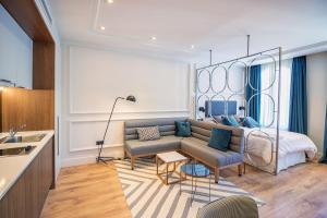 salon z kanapą i łóżkiem w obiekcie Livemalaga Centro Suites w Maladze
