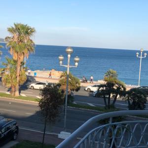 a view of the beach and the ocean from a balcony at Apartment 2 chambres Palais HenriIV in Nice
