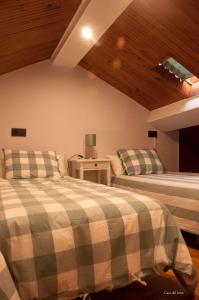 a bedroom with two beds and a wooden ceiling at Casa Del Beso in Luarca
