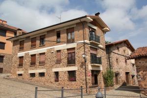 un gran edificio de ladrillo con ventanas en una calle en Apartamento Turísticos Luar 3, en El Rasillo