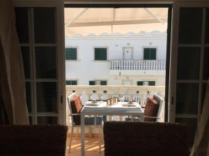 a table and chairs with a view of a balcony at SS Tavira in Cabanas de Tavira
