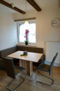 a dining room with a table and two chairs at M&A Ferienwohnungen Oberbayern in Peiting +2 photos