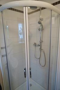 a bathroom with a shower with a glass door at M&A Ferienwohnungen Oberbayern in Peiting