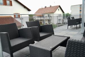 a group of chairs and tables on a balcony at M&A Ferienwohnungen Oberbayern in Peiting