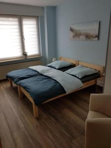 a bedroom with two beds and a couch and two windows at Wiehenkrug in Lübbecke