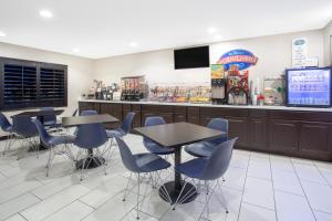 un restaurant avec des tables, des chaises et un comptoir dans l'établissement Baymont by Wyndham Phoenix I-10 near 51st Ave, à Phoenix