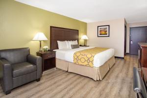 una stanza d'albergo con un letto e una sedia di Baymont by Wyndham Phoenix I-10 near 51st Ave a Phoenix
