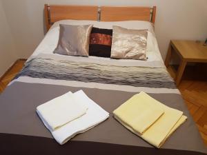 a bed with two towels sitting on top of it at Apartment Gdańsk Wrzeszcz in Gdańsk